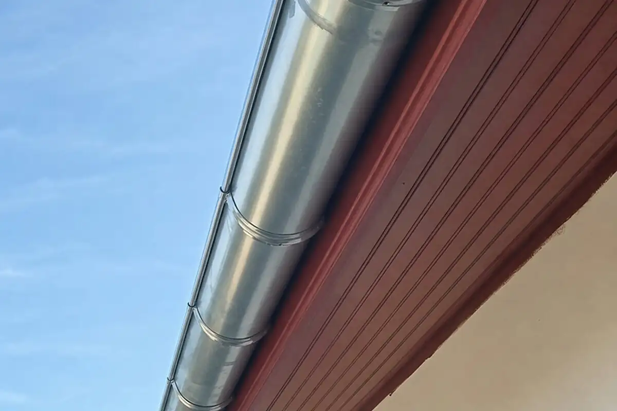 Gouttière et descente en zinc posées sur une maison aux volets rouges à Bidart par 2C Couvreur Bayonne