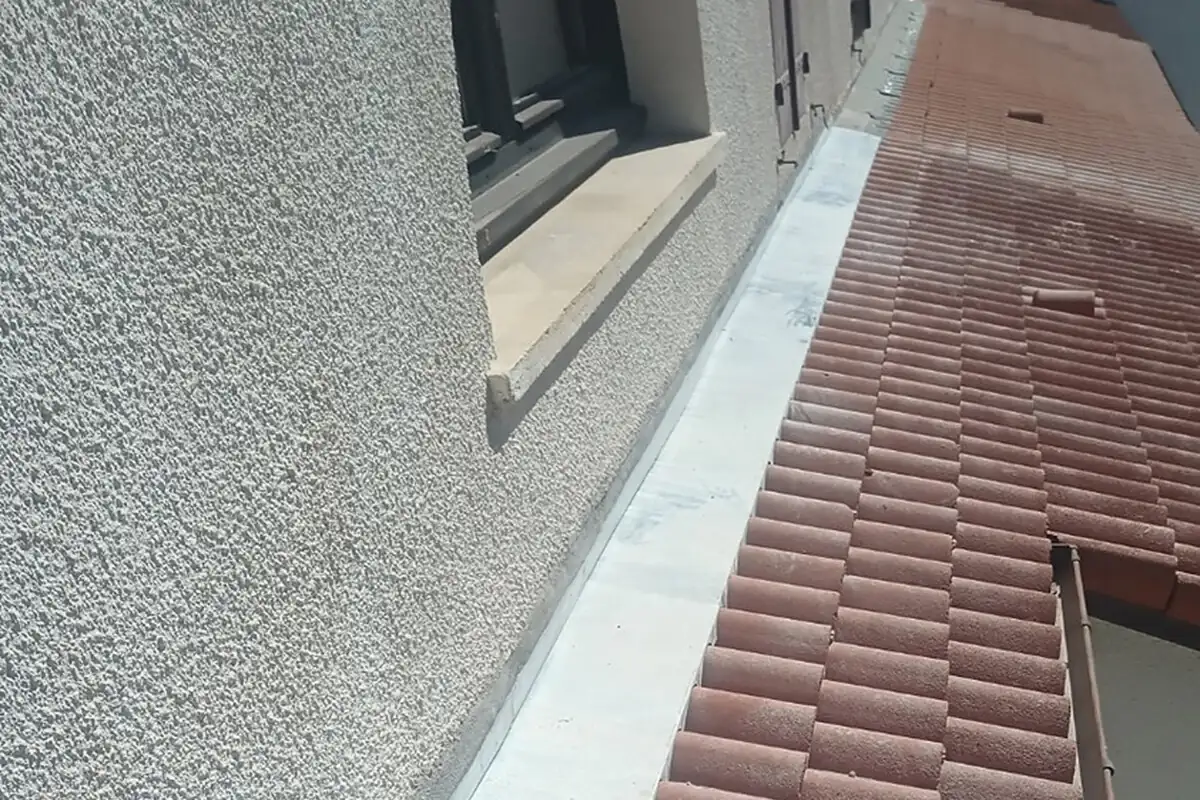 Bavette de faîtage en zinc posée en tête de mur le long d'un rampant en tuiles à Biarritz par 2C Couvreur Bayonne