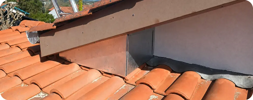 Chéneau en zinc entre deux pans de toiture en tuiles, entretenu avec la couverture