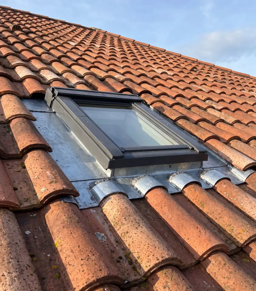 Velux posé par un couvreur-zingueur sur une toiture en tuiles canal au Pays Basque