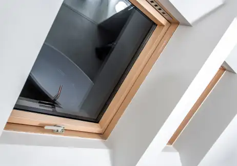 Fenêtre de toit Velux à cadre bois vue de l'intérieur des combles, ébrasement blanc
