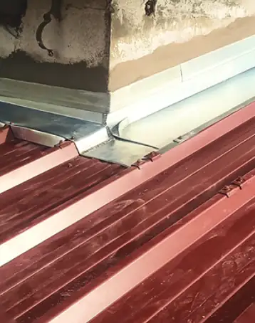Raccord en zinc entre un mur et une toiture en bac acier pour rétablir l'étanchéité, secteur de Bayonne