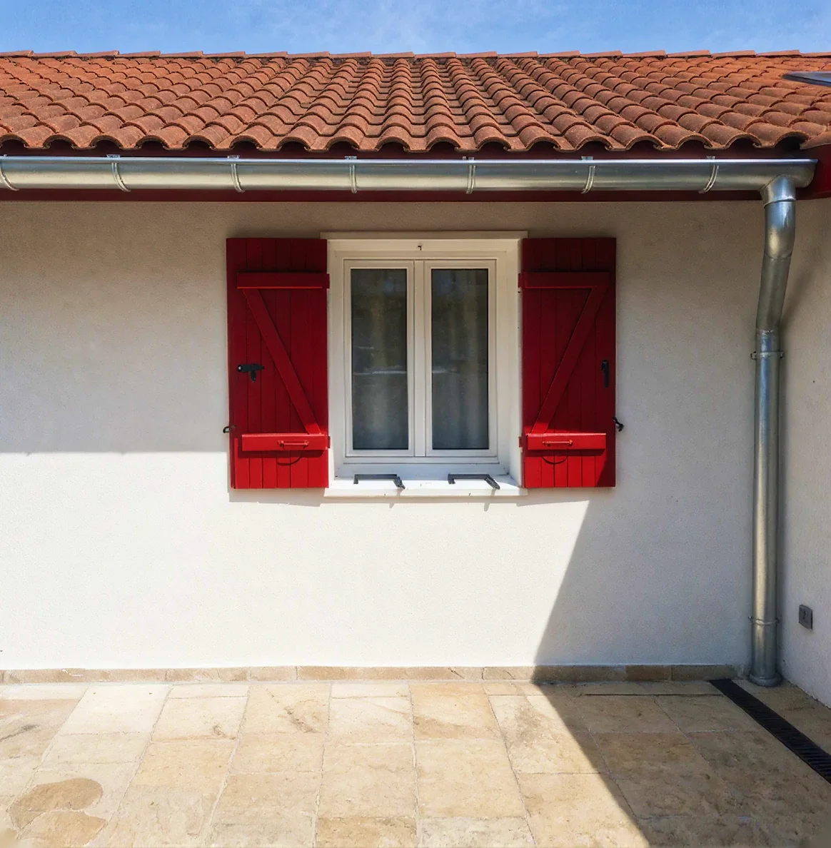 Maison basque et sa descente en zinc après une rénovation de toiture à Bayonne