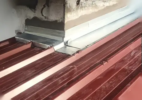 Bavette en zinc posée au pied d'un mur sur une couverture en bac acier, secteur de Bayonne
