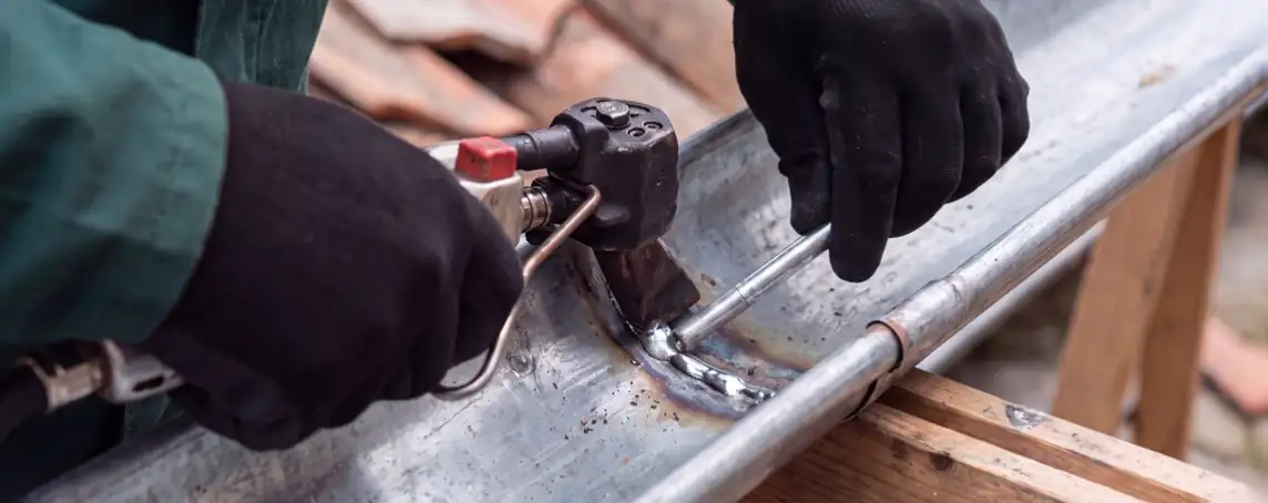 Reprise d'un raccord de gouttière en zinc par l'artisan, réparation de gouttière à Bayonne
