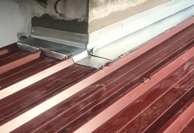 Raccord zinc entre un toit en bac acier et un mur, réalisé à Bayonne