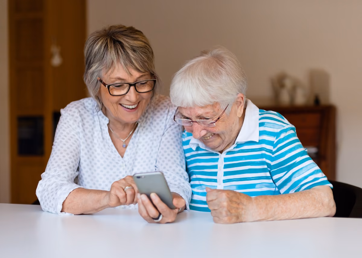 Two senior women looking at phone