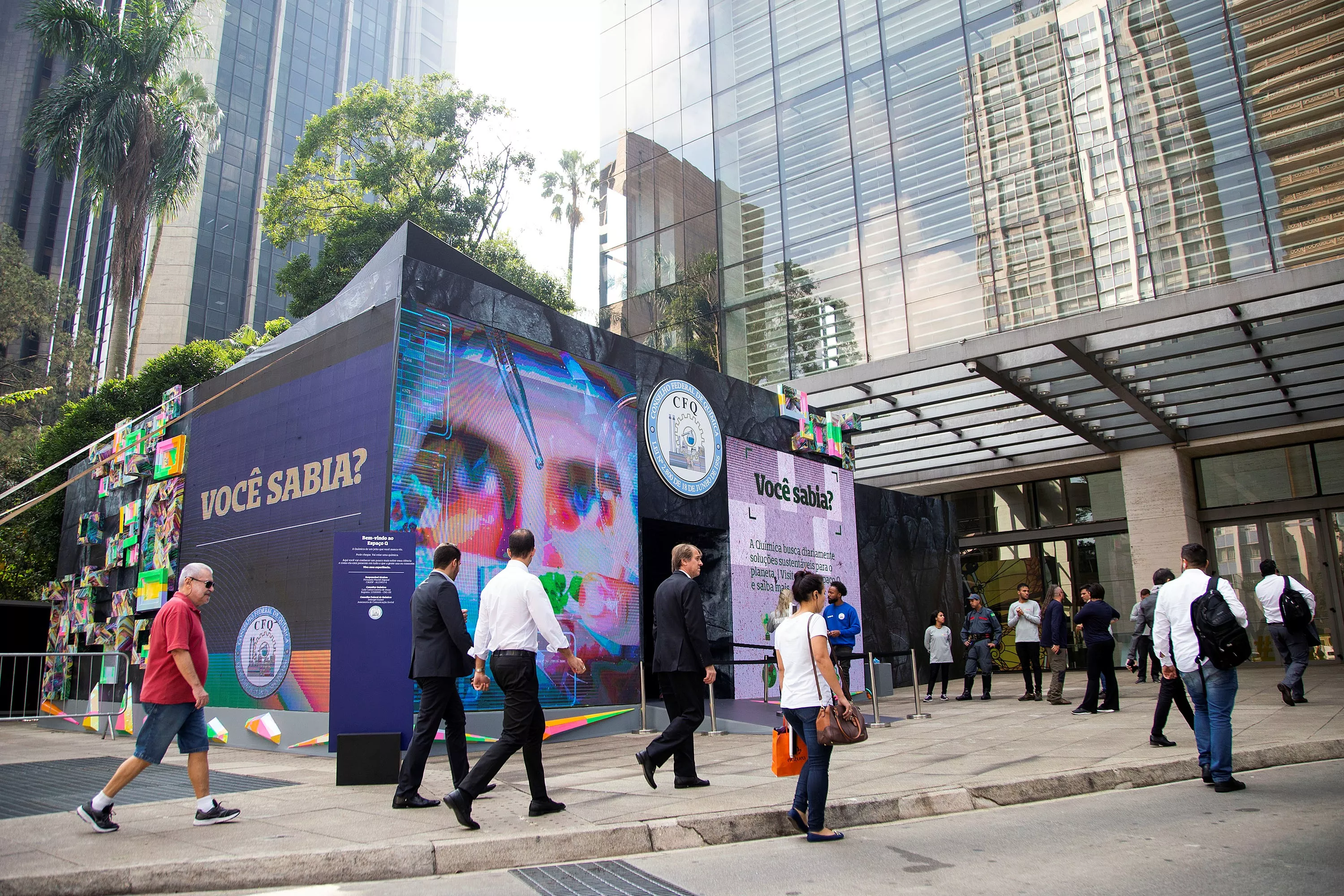 The Espaço Q pavilion on Avenida Paulista, passers-by crossing in front of its printed walls