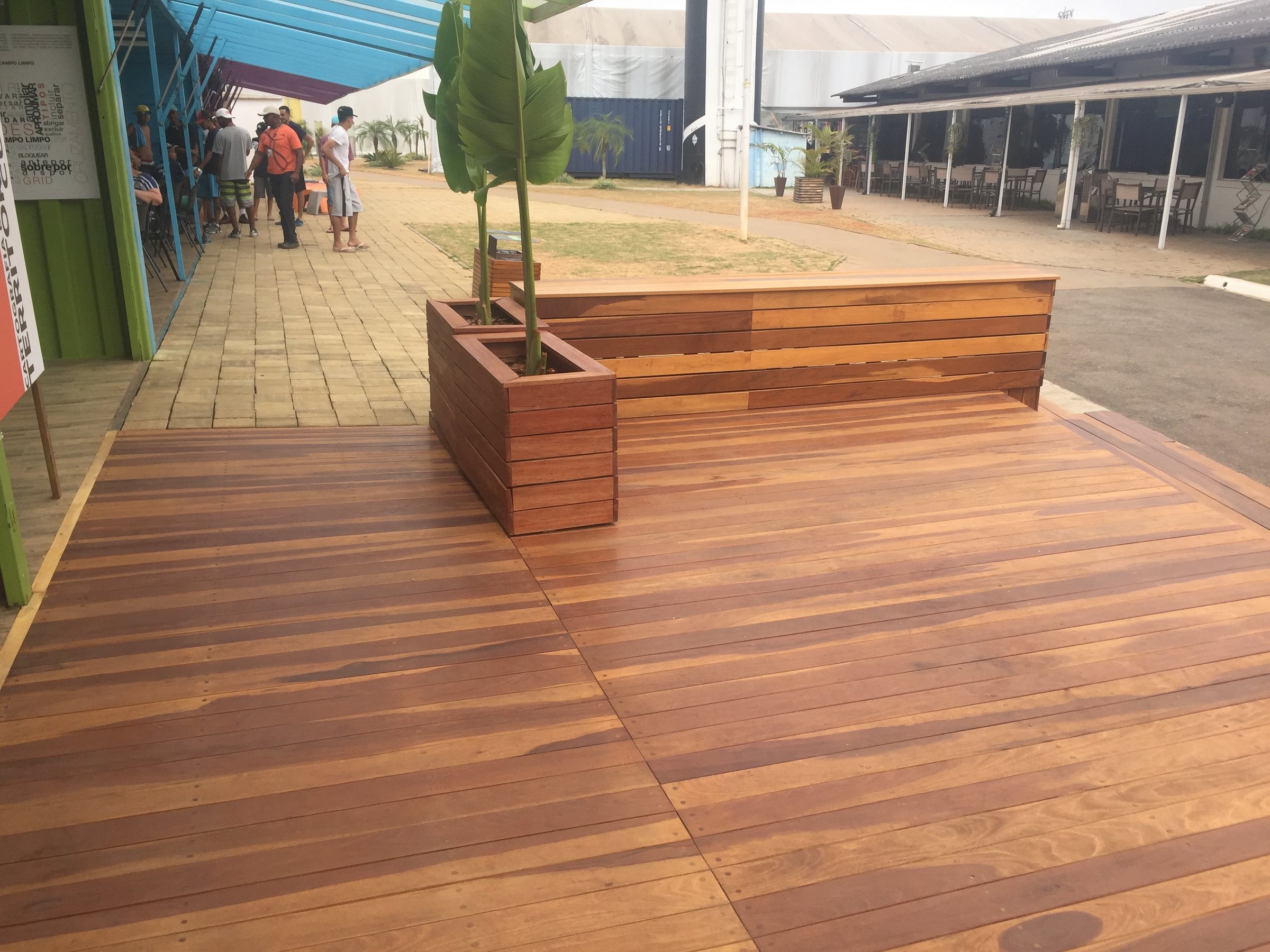Sesc · 2017 · Sesc Verão — The timber deck and planters running between the pavilions, with visitors walking through.