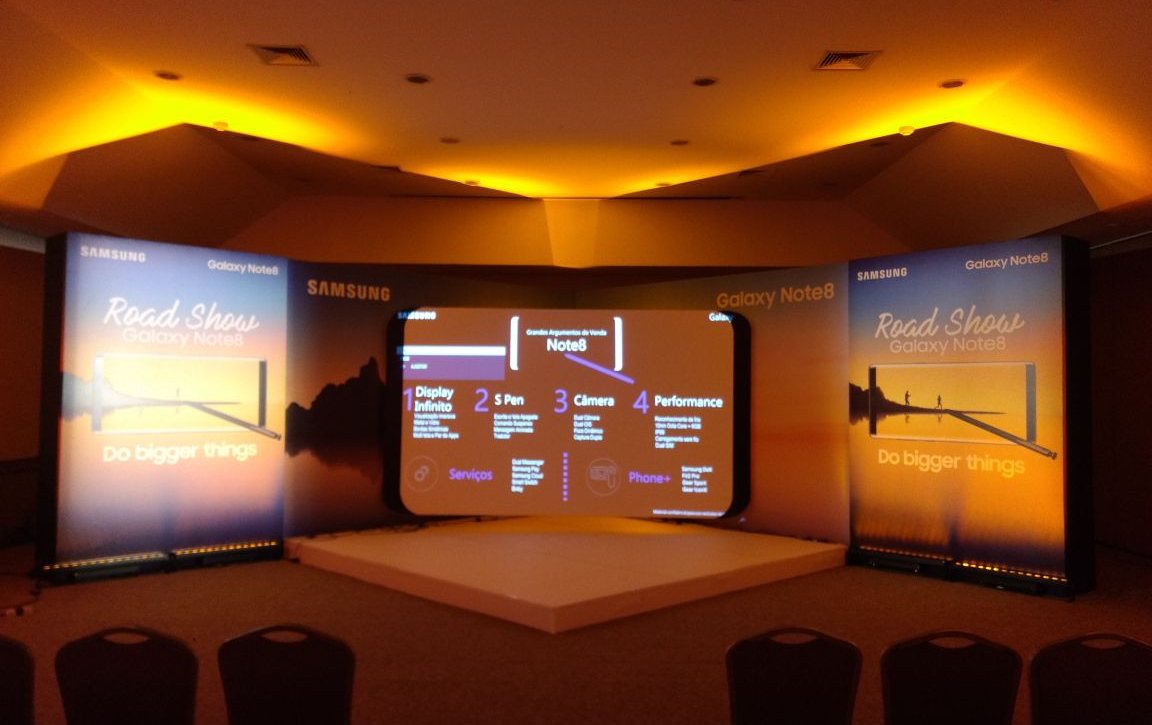 Samsung · 2018 — A product-launch auditorium with its warm-lit stage and screen wall.
