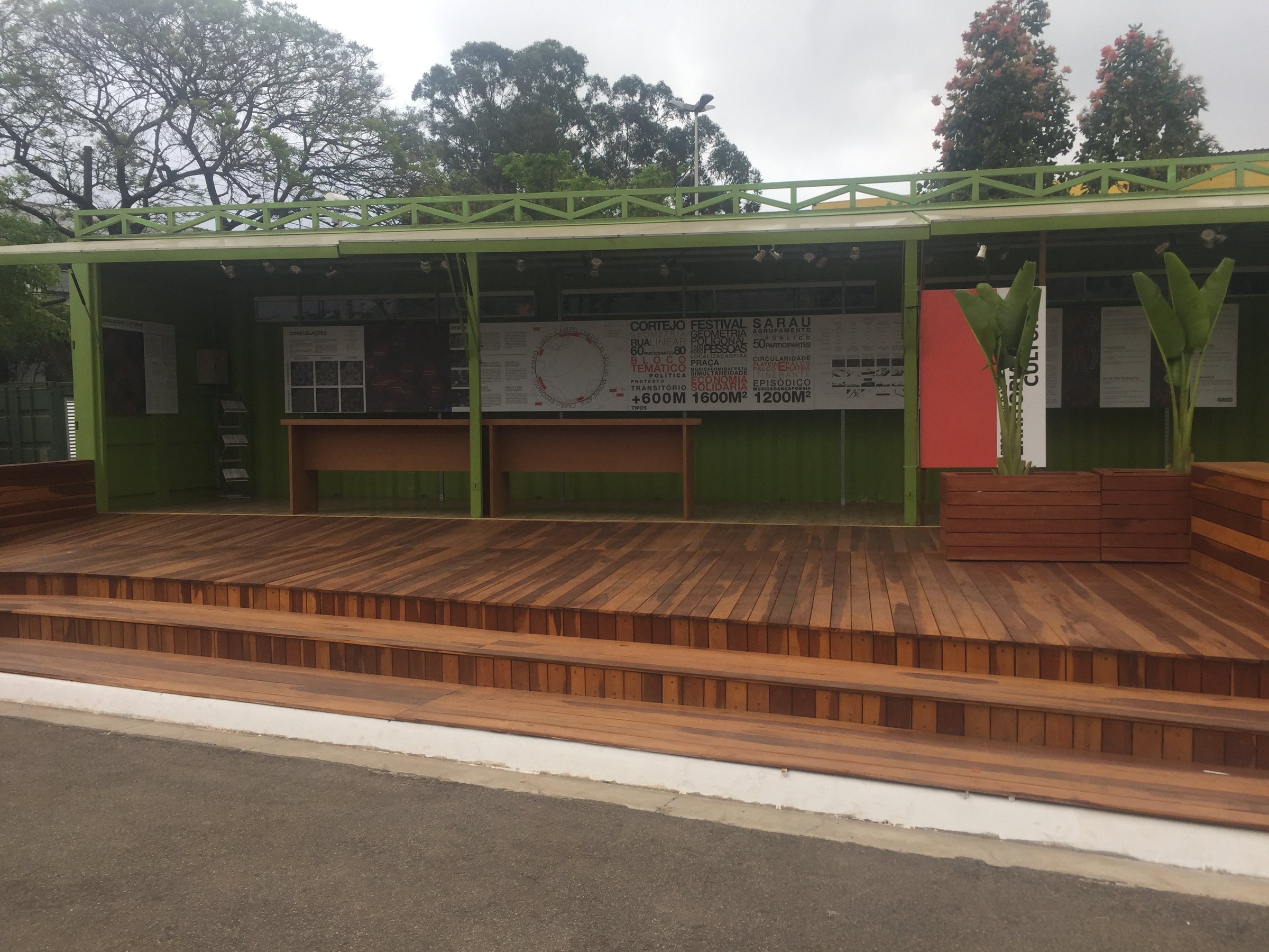 Sesc · 2017 · Sesc Verão — The built timber pavilion with green panels and a stepped deck, seen from the park.