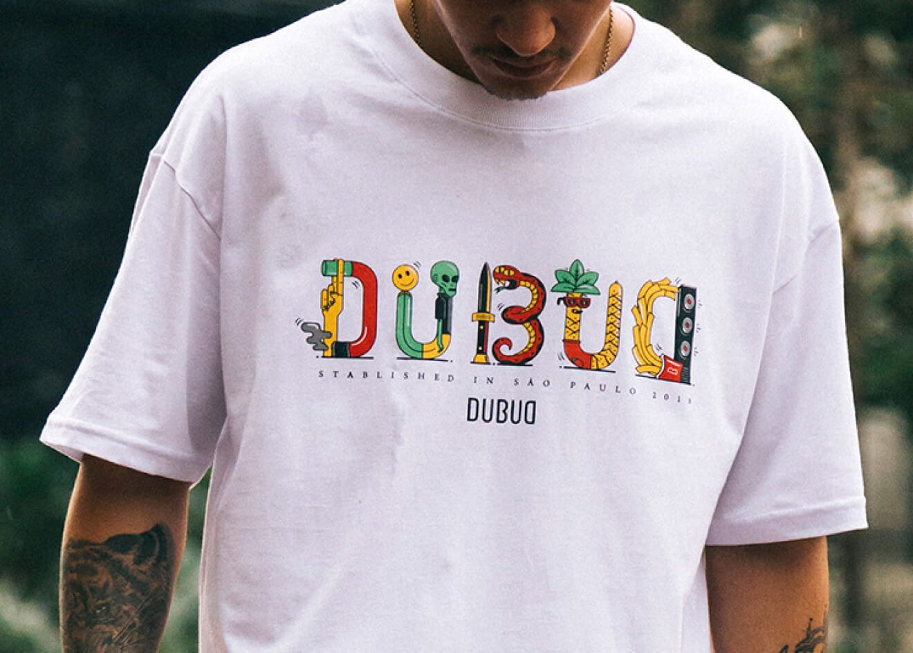 Dubud — white tee with the multicolour illustrated Dubud logotype