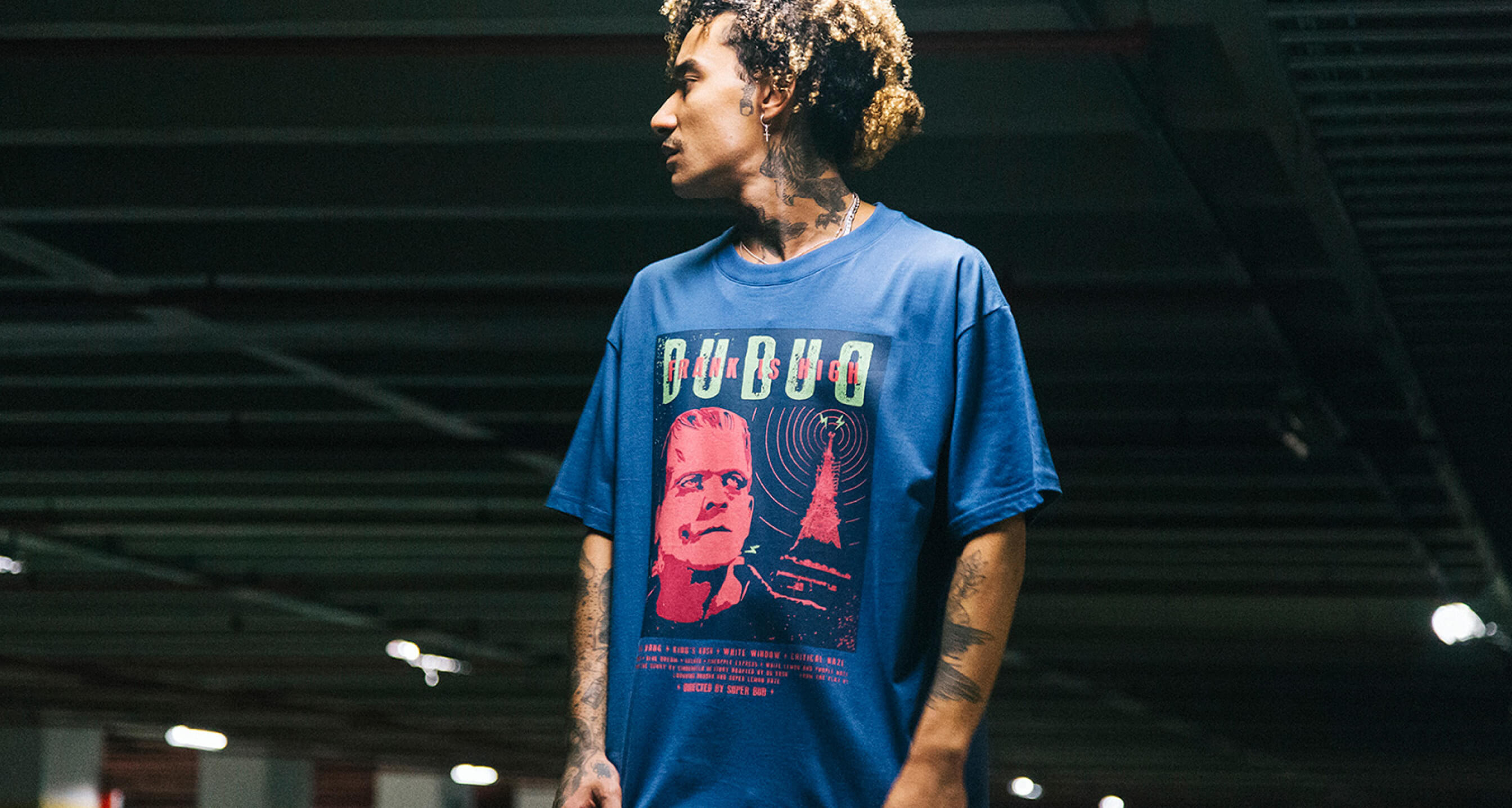 Dubud — blue printed tee worn in a garage