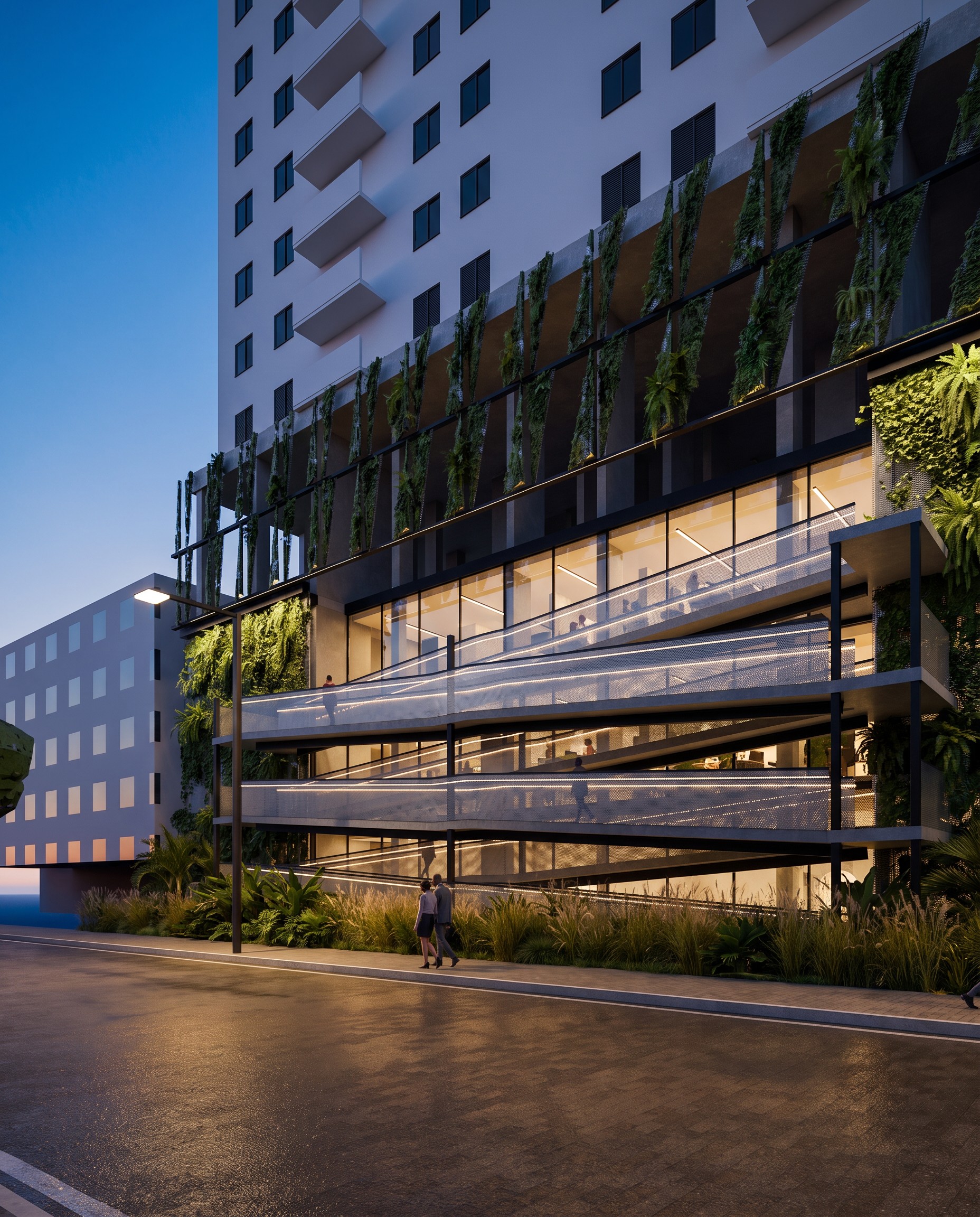 The coworking under the tower at blue hour, seen from across the street: the ramp's warm handrails zigzag up the face, planted brise fins below the tower