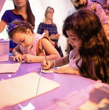 Children writing their letters at the post office counter