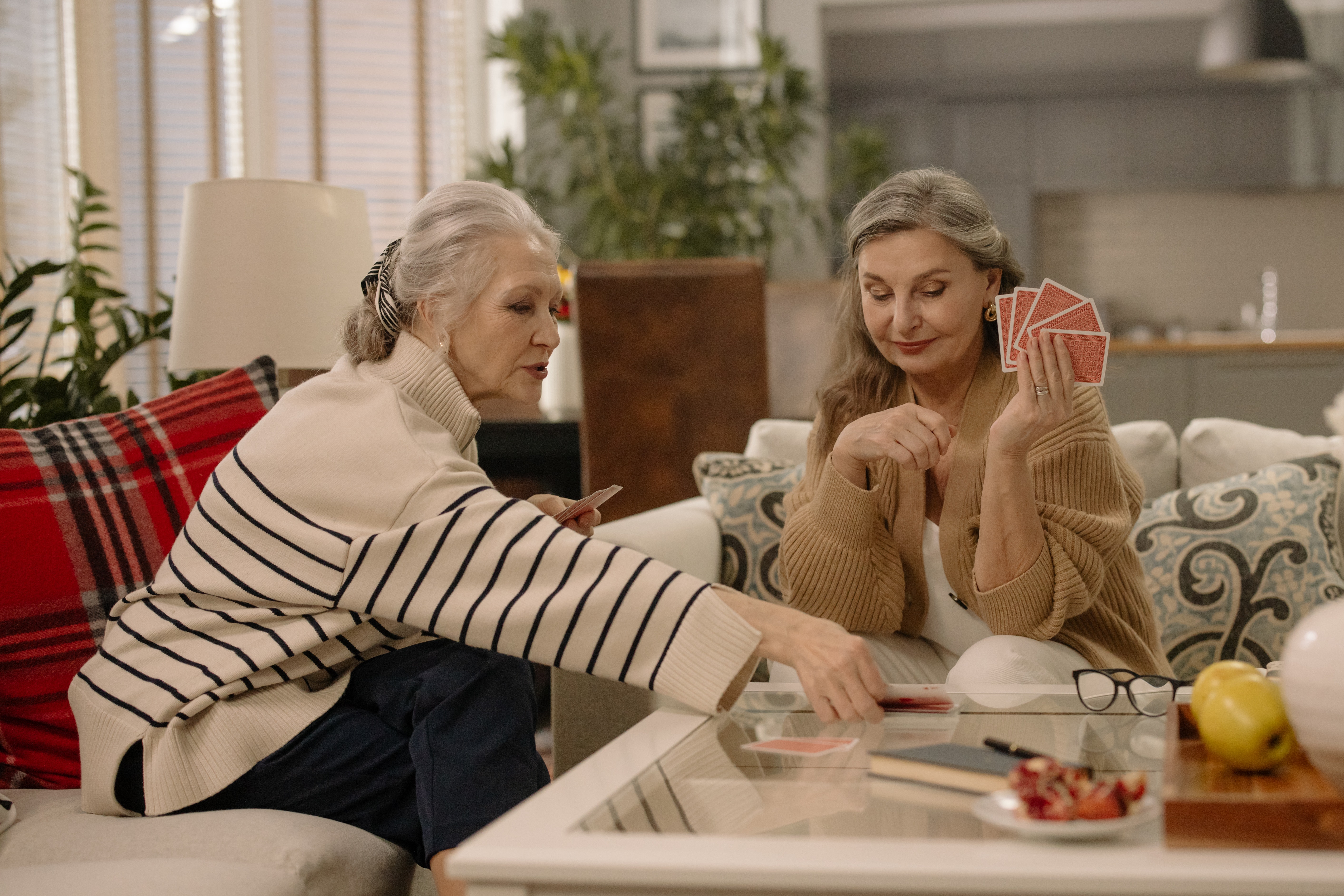 Women playing cards on couch stock image