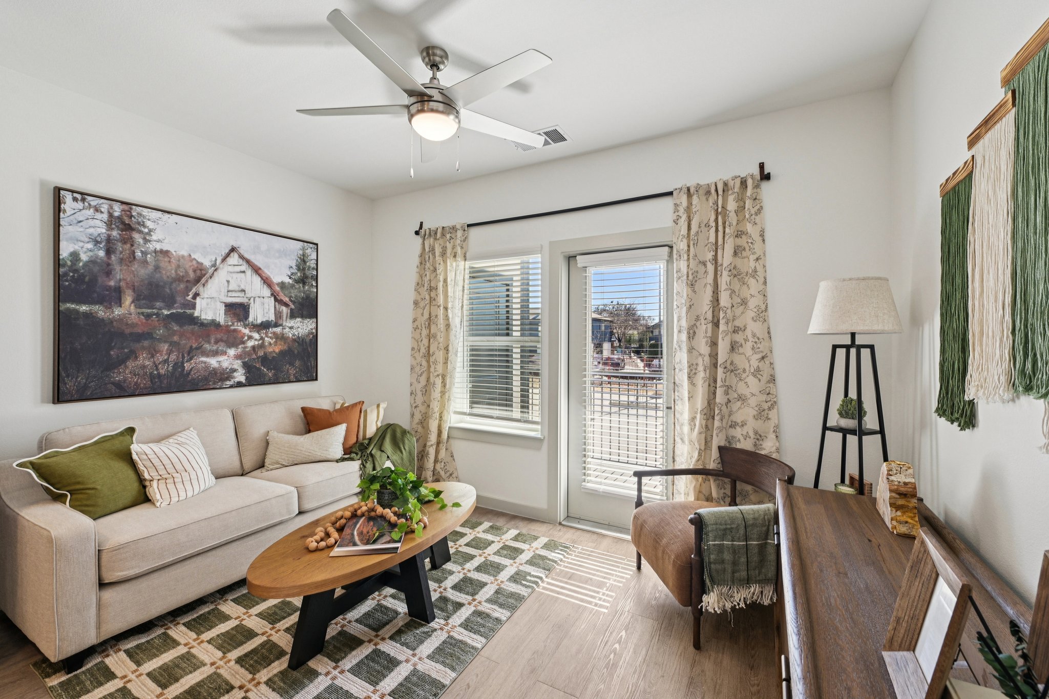 Living area with sofa and large window and access with balcony