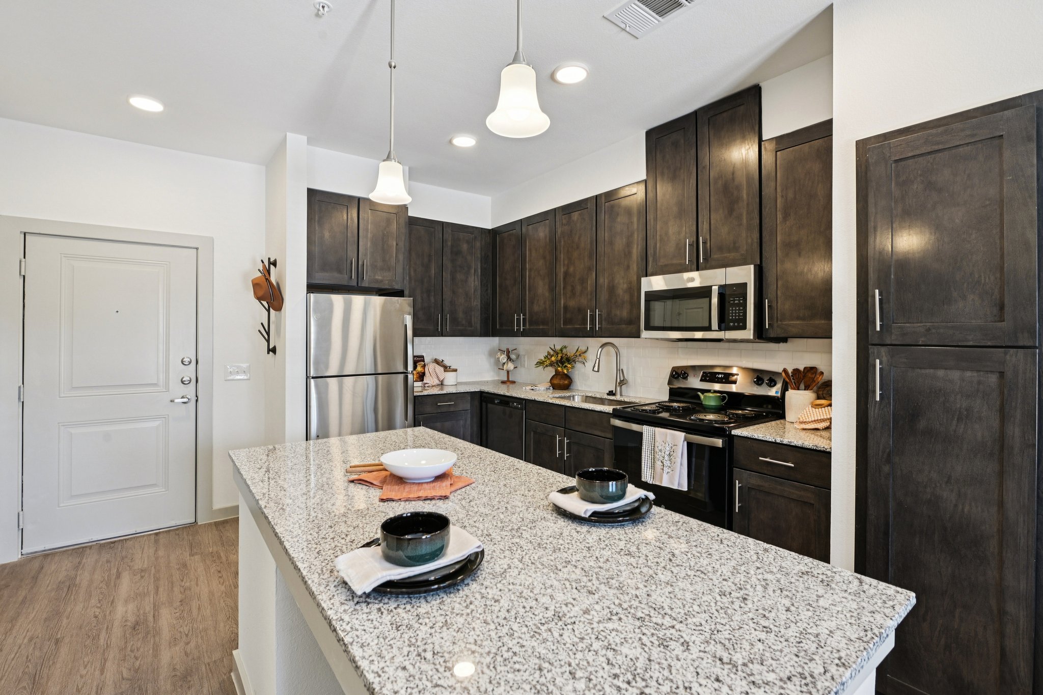 Kitchen with dark cabinets and stainless steel appliances