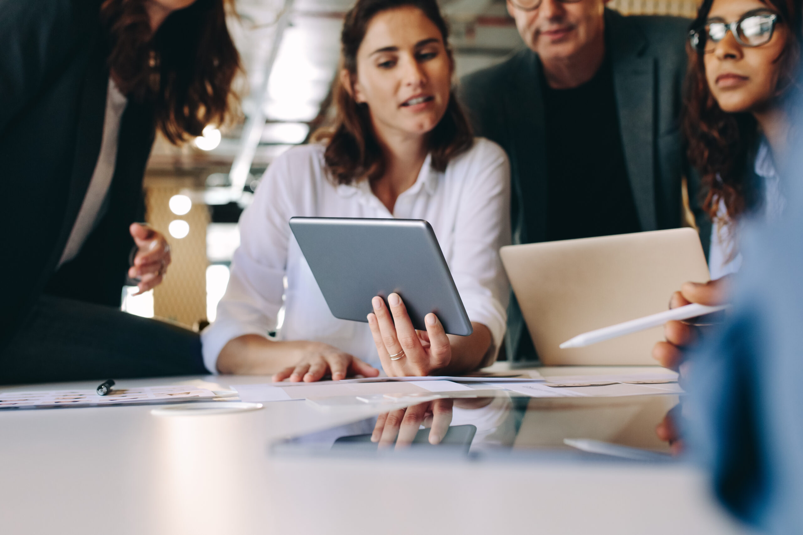 A small team gathered around a tablet, talking through a plan