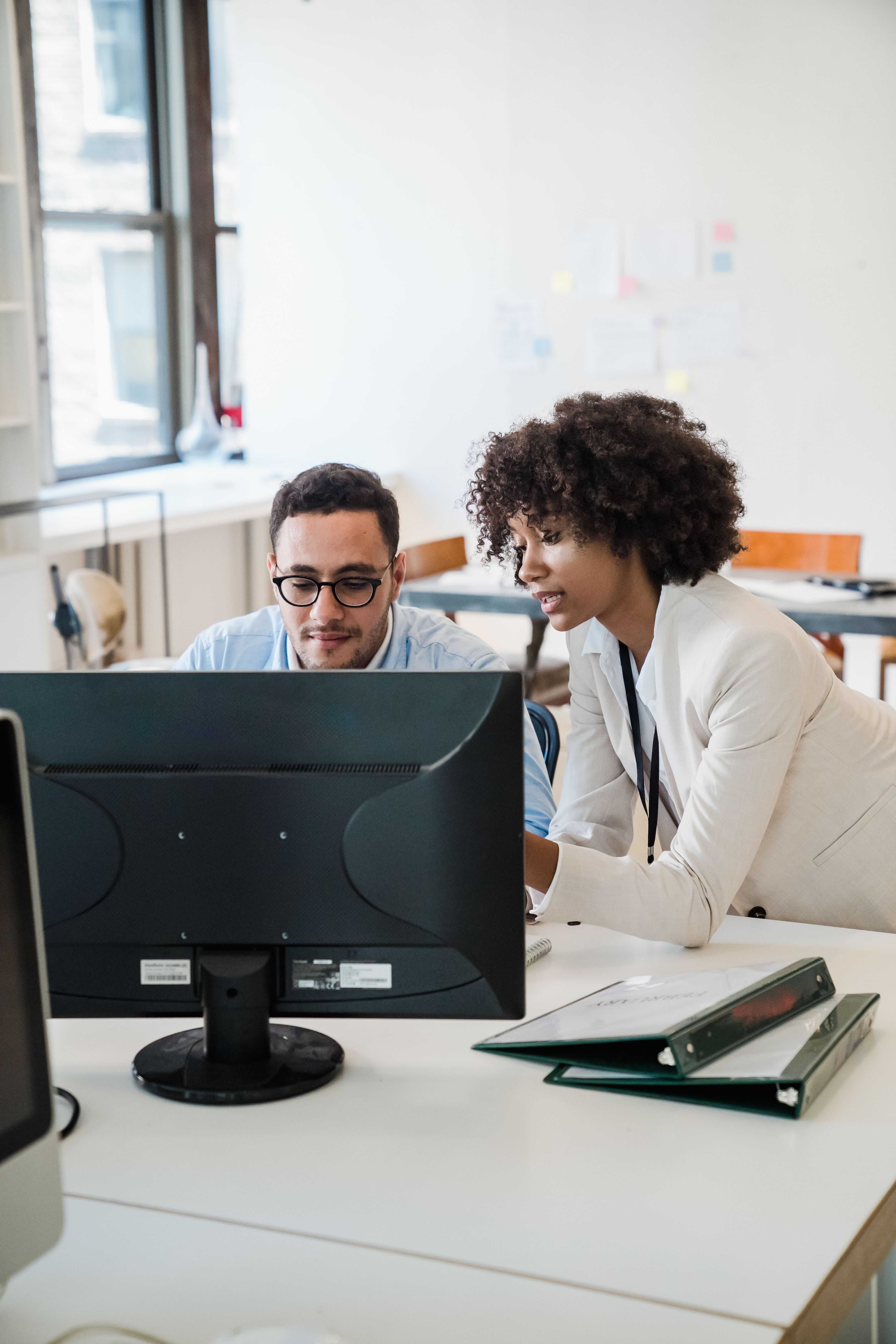 Two colleagues working together on a computer.