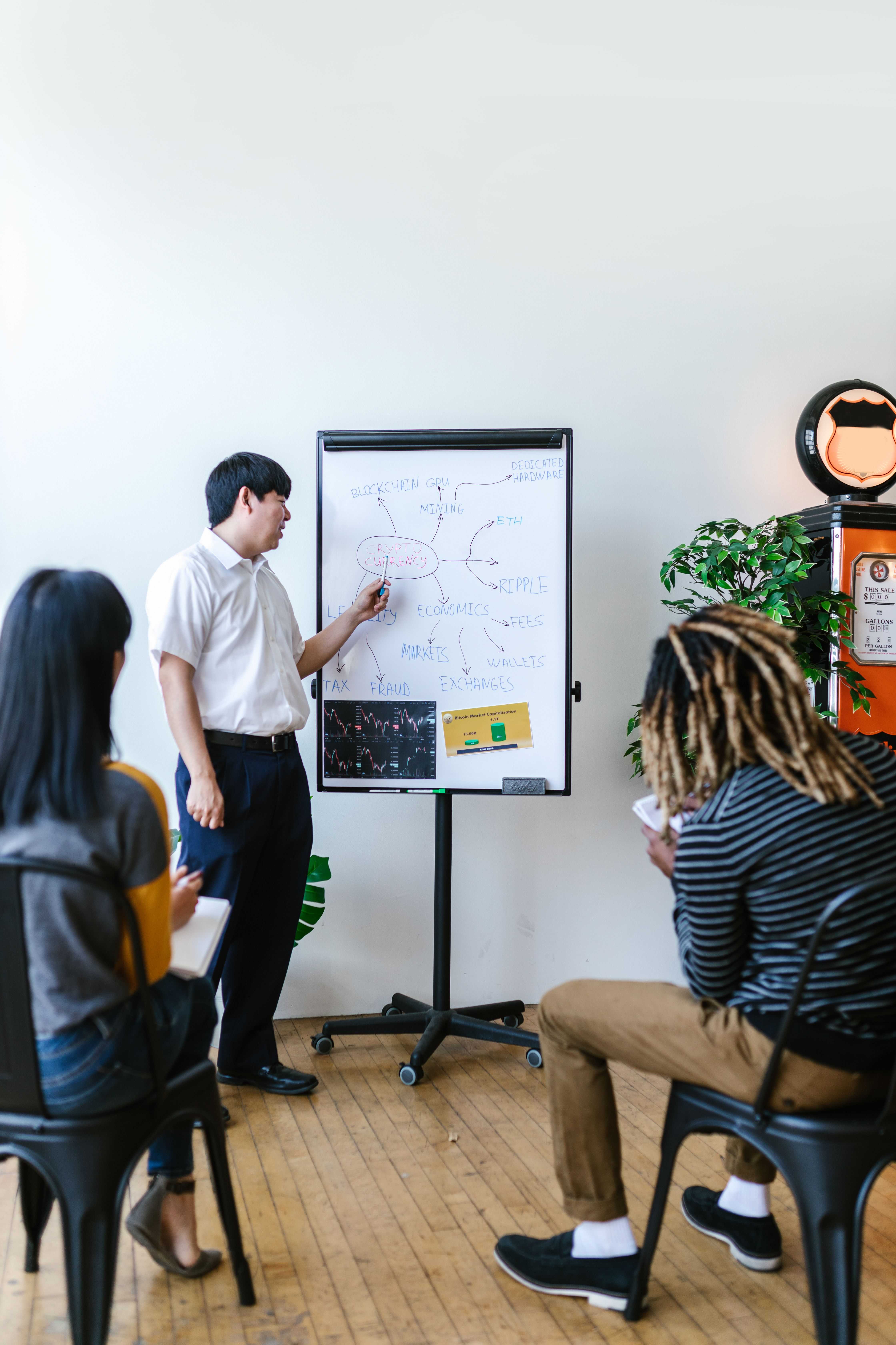 Presenter explaining a diagram on a whiteboard.