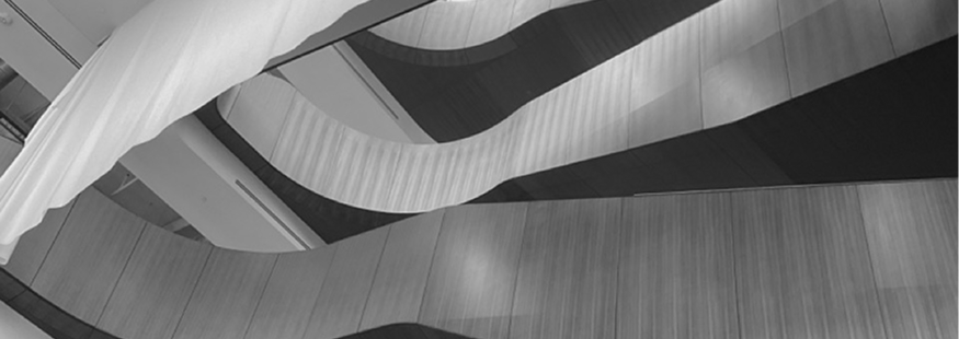 Curved wooden and white fabric architectural ceiling detail with flowing lines and shadows.