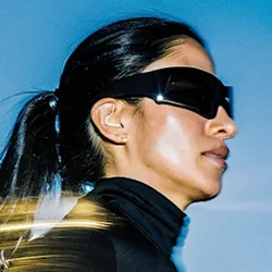 Focused woman with intense expression during a gym workout, showing muscular definition and determination.