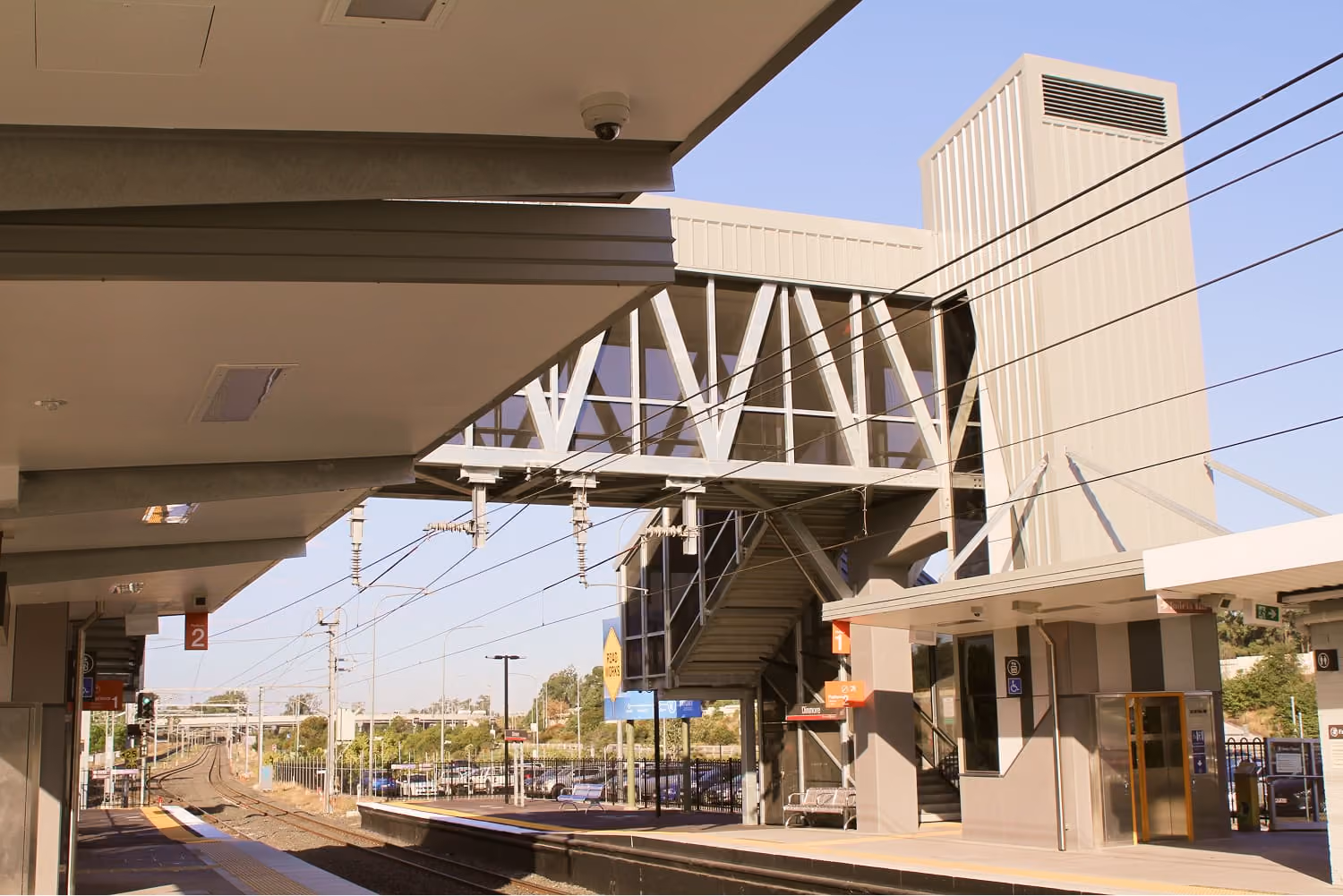 Railway station platform with a covered footbridge and lift tower