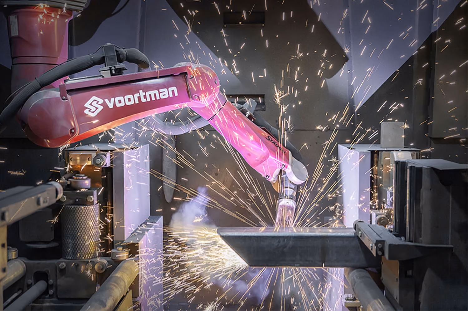 Robotic welding arm cutting steel with sparks in a fabrication workshop