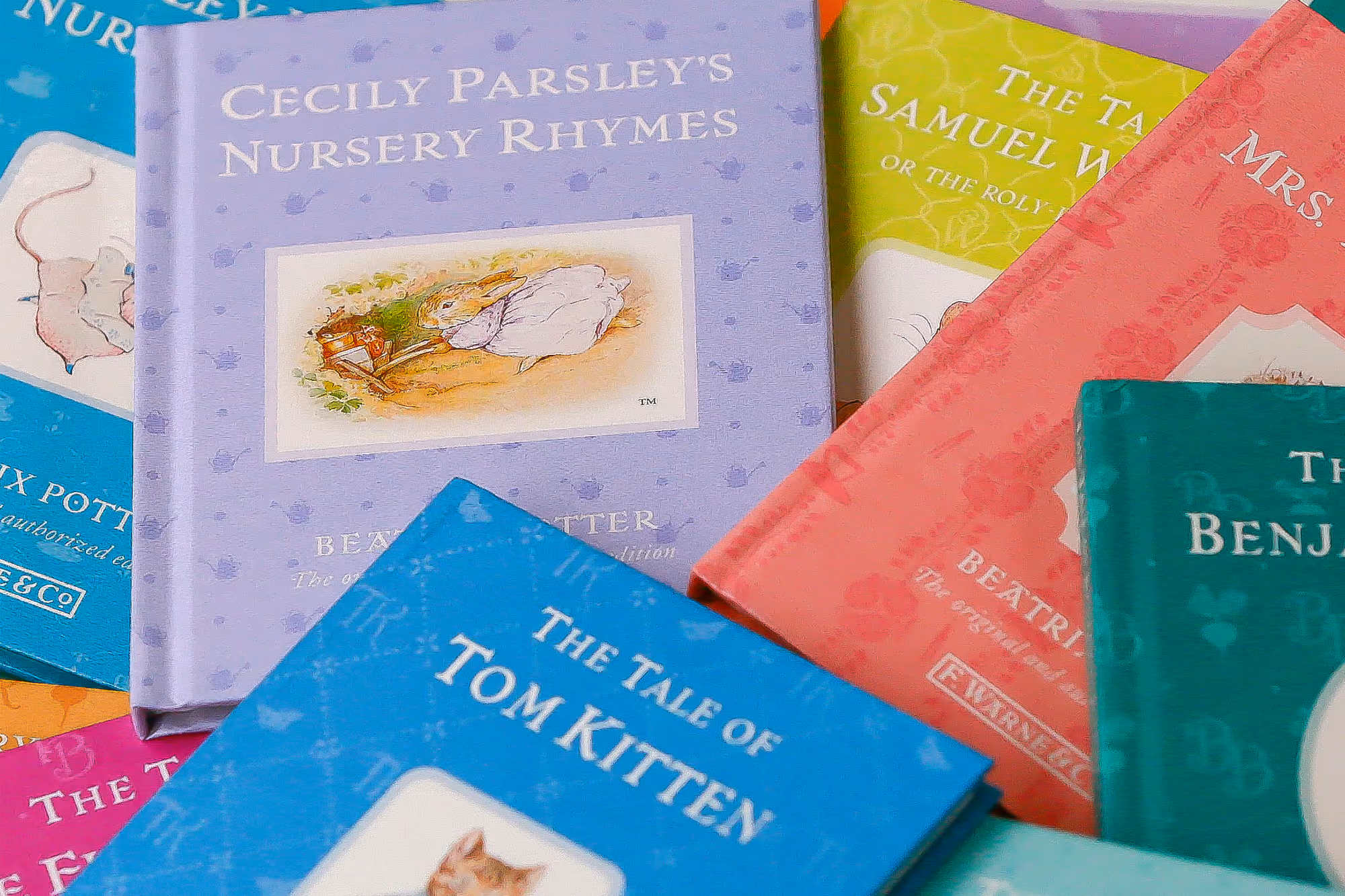 A collection of vintage Beatrix Potter storybooks, including The Tale of Tom Kitten, from the cottage bookshelves.