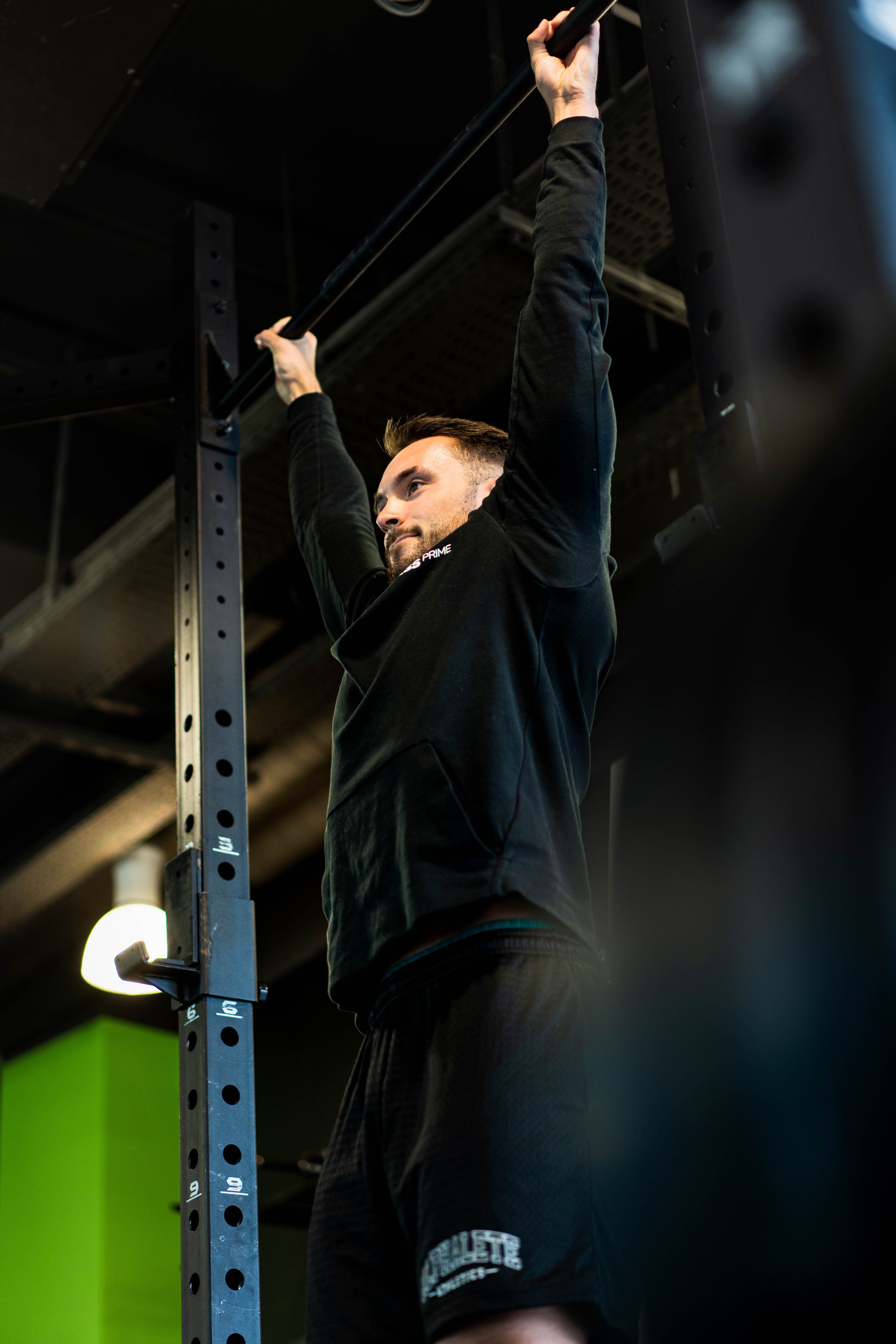 Un adherent accompagne par un coach sur le plateau de musculation