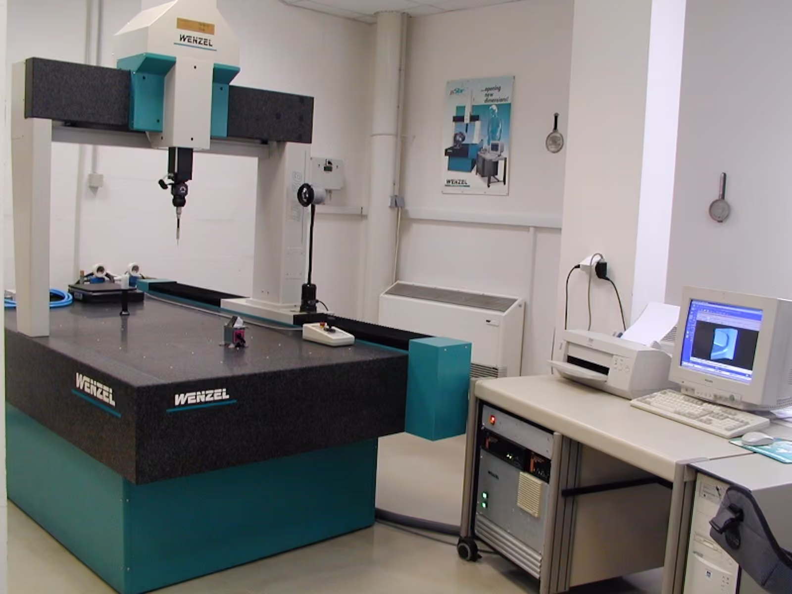 Wenzel coordinate measuring machine on a granite table in the measuring room, with its measurement PC and printer alongside.
