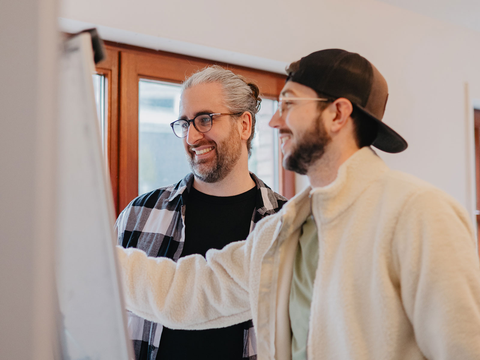Moritz Keil und Dr. Nico Thümler arbeiten gut gelaunt an einem Flipchart