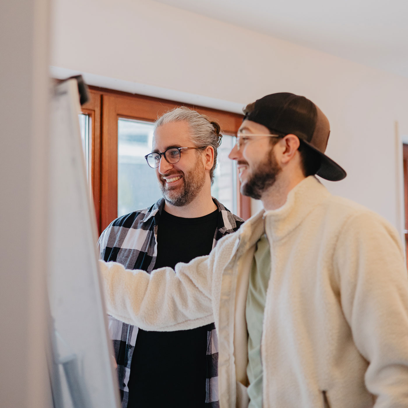 Moritz Keil und Dr. Nico Thümler arbeiten gut gelaunt an einem Flipchart
