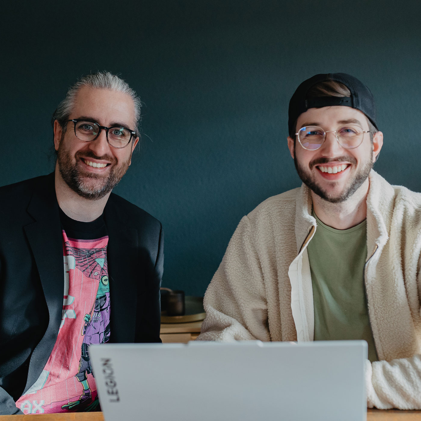 Moritz Keil und Dr. Nico Thümler sitzen lachend am Laptop