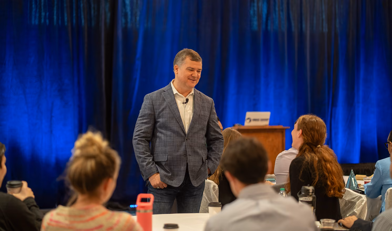 Robert "Cujo" Teschner leading a VMax Group leadership workshop with participants at round tables