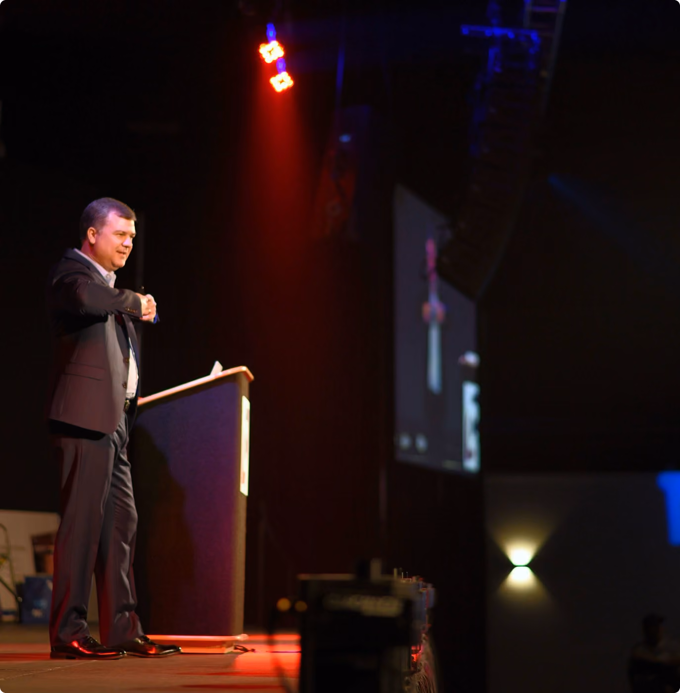 Robert "Cujo" Teschner, leadership keynote speaker, at the lectern under stage lighting