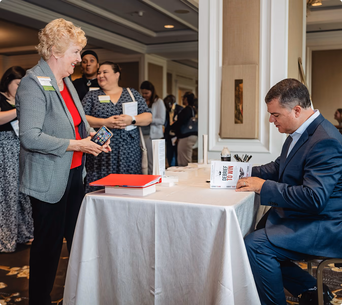 Robert "Cujo" Teschner signing books for attendees after a leadership keynote on team accountability