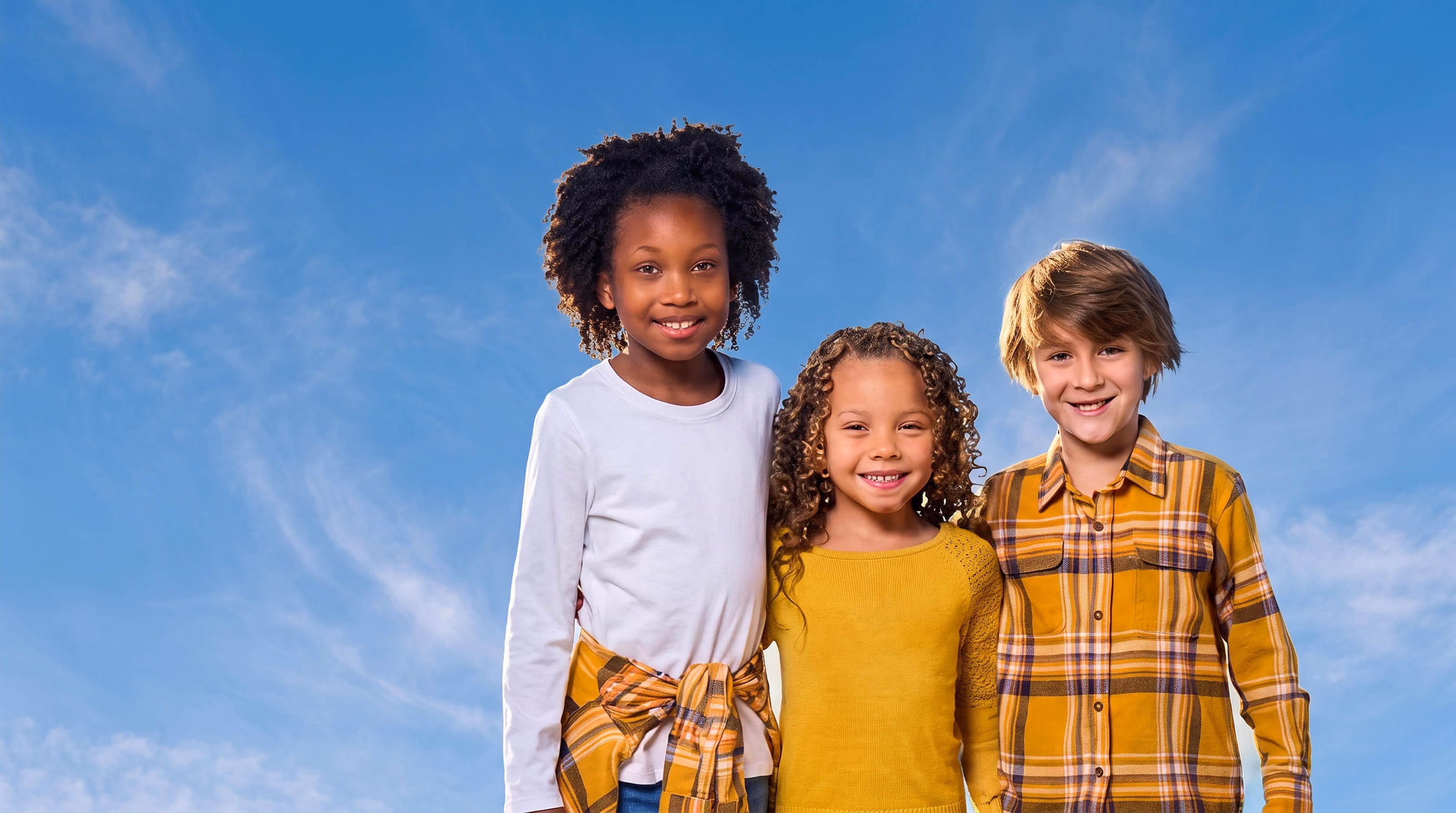 3 happy kids looking at the camera and smiling
