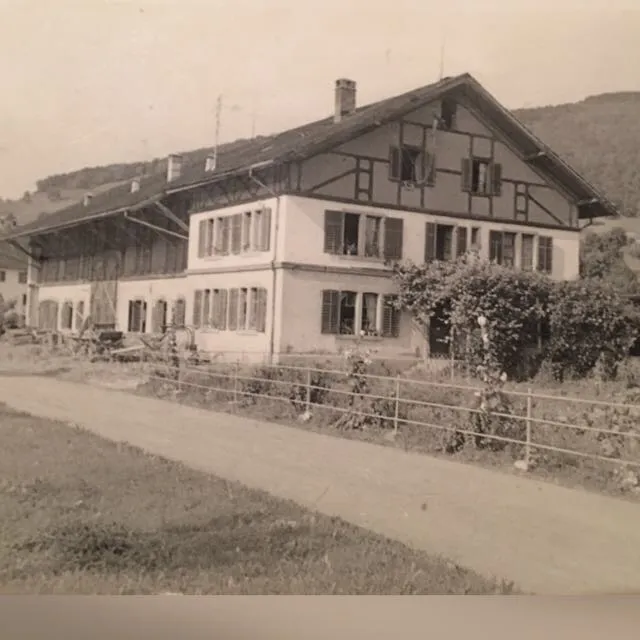 Historische Schwarz-Weiss-Aufnahme des Bauernhofs in Rorbas mit Wohnhaus, Scheune und Zufahrtsweg