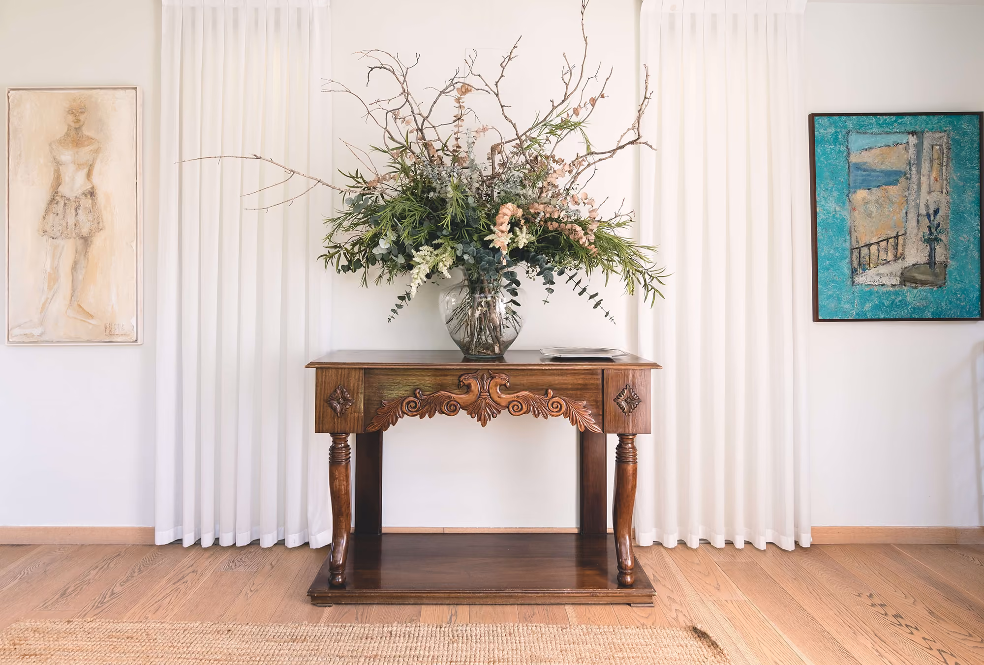 Ljust rum med mönstrat trägolv, konst och blommor – Inspiration för golvläggning och slipning i Stockholm från Trägolvsmästarna.