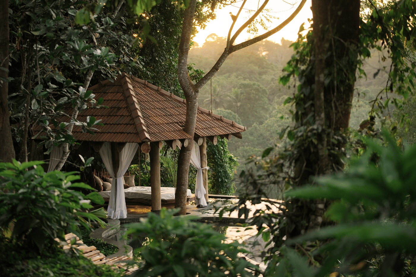 Poolside pavilion with a daybed beside a lily pond