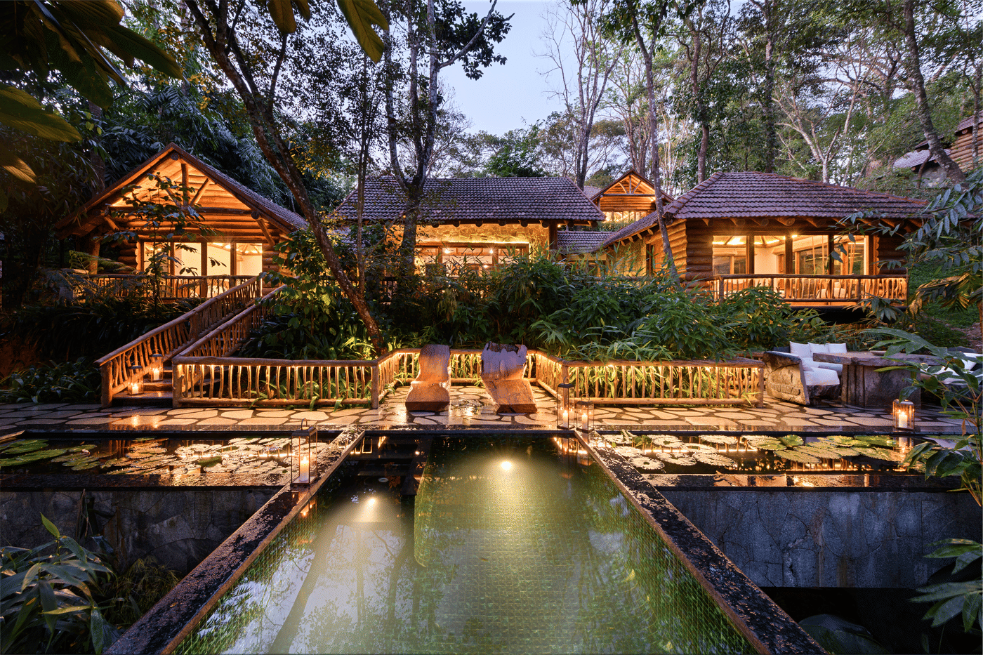 Log bungalows at Estate Plavu lit at dusk