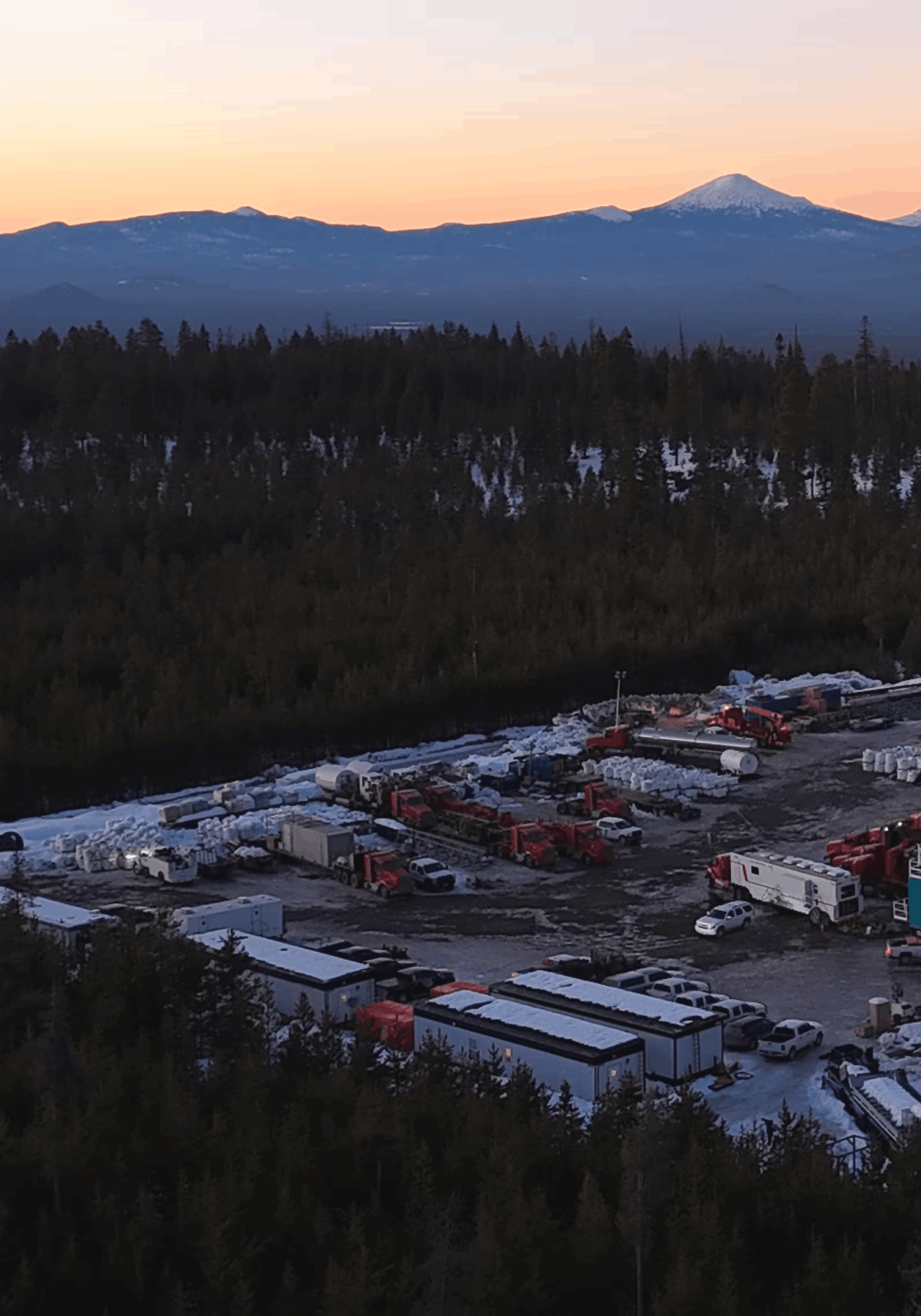 Geothermal mountain landscape at dusk over a drilling site