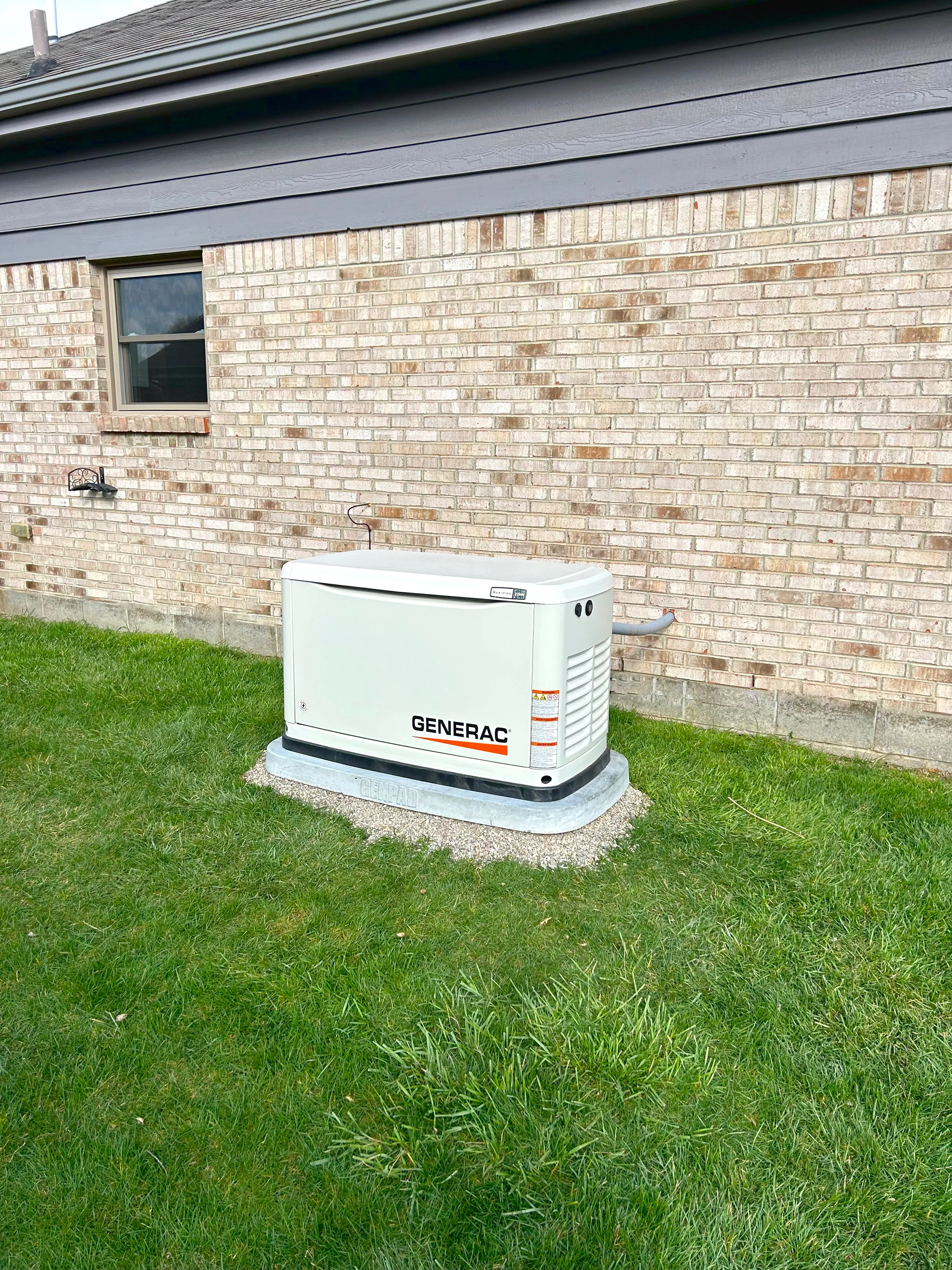 Generac generator outside a brick house