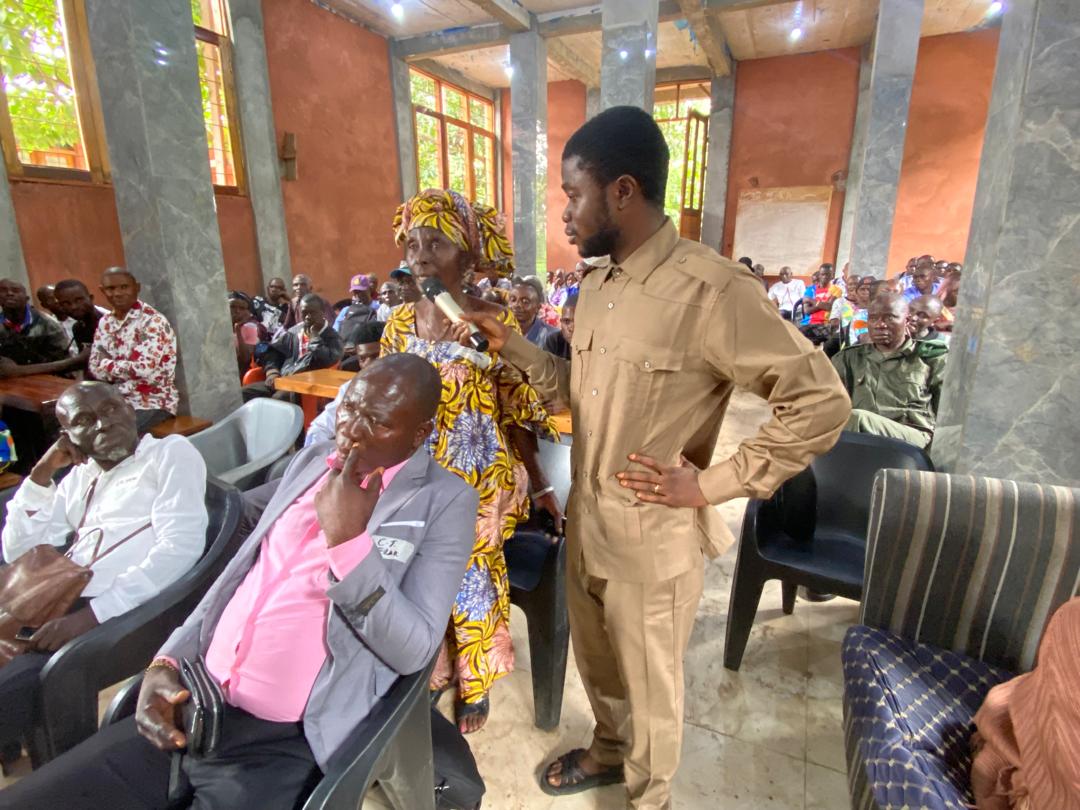 Participants assis dans la salle de l’Assemblée générale communautaire, à Idiofa.