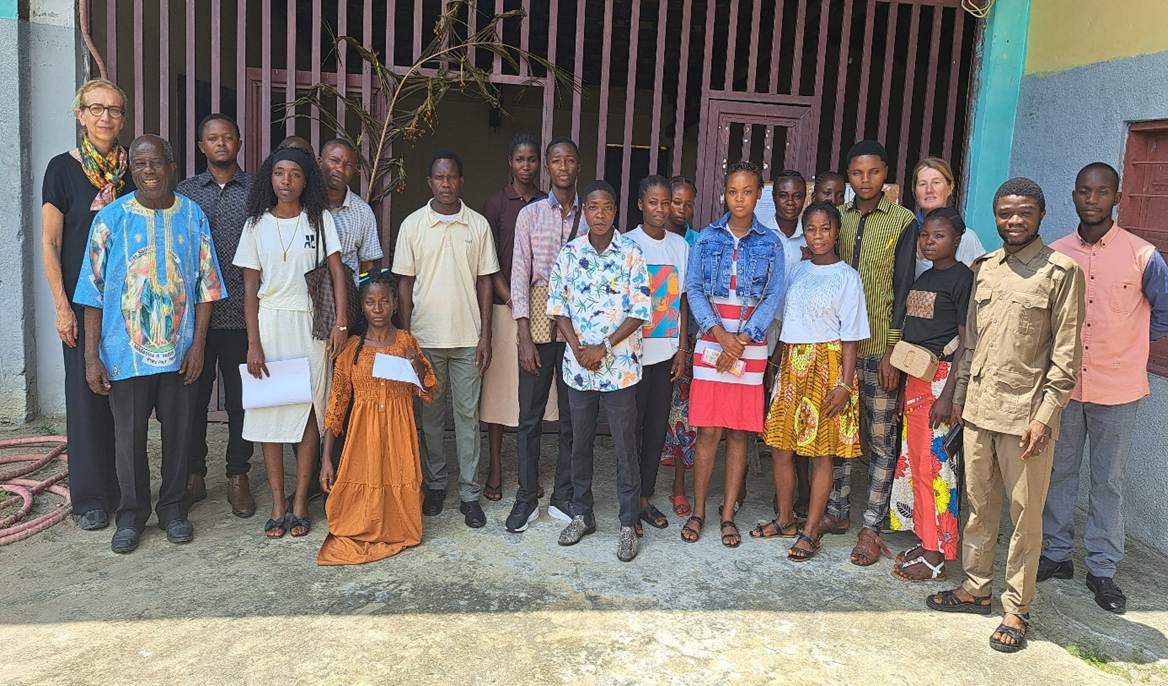 Photo de groupe d’enseignants et d’étudiants devant un bâtiment.