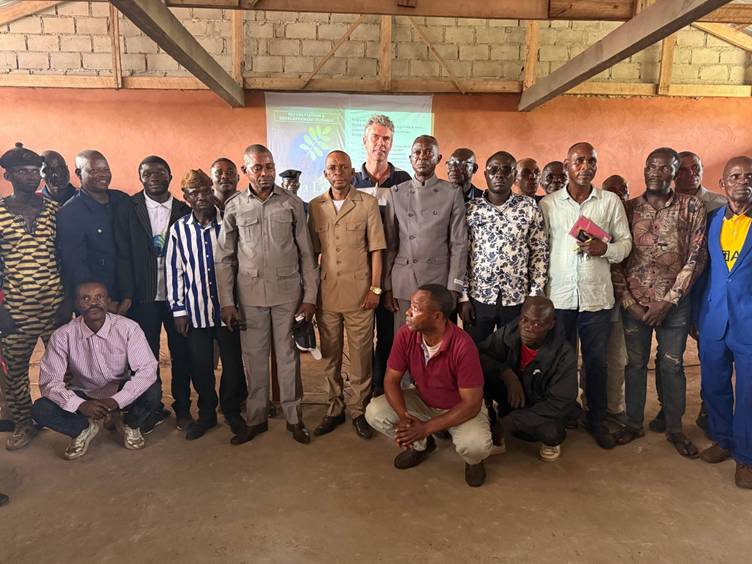 Photo de groupe d’une trentaine d’hommes dans une salle de réunion.