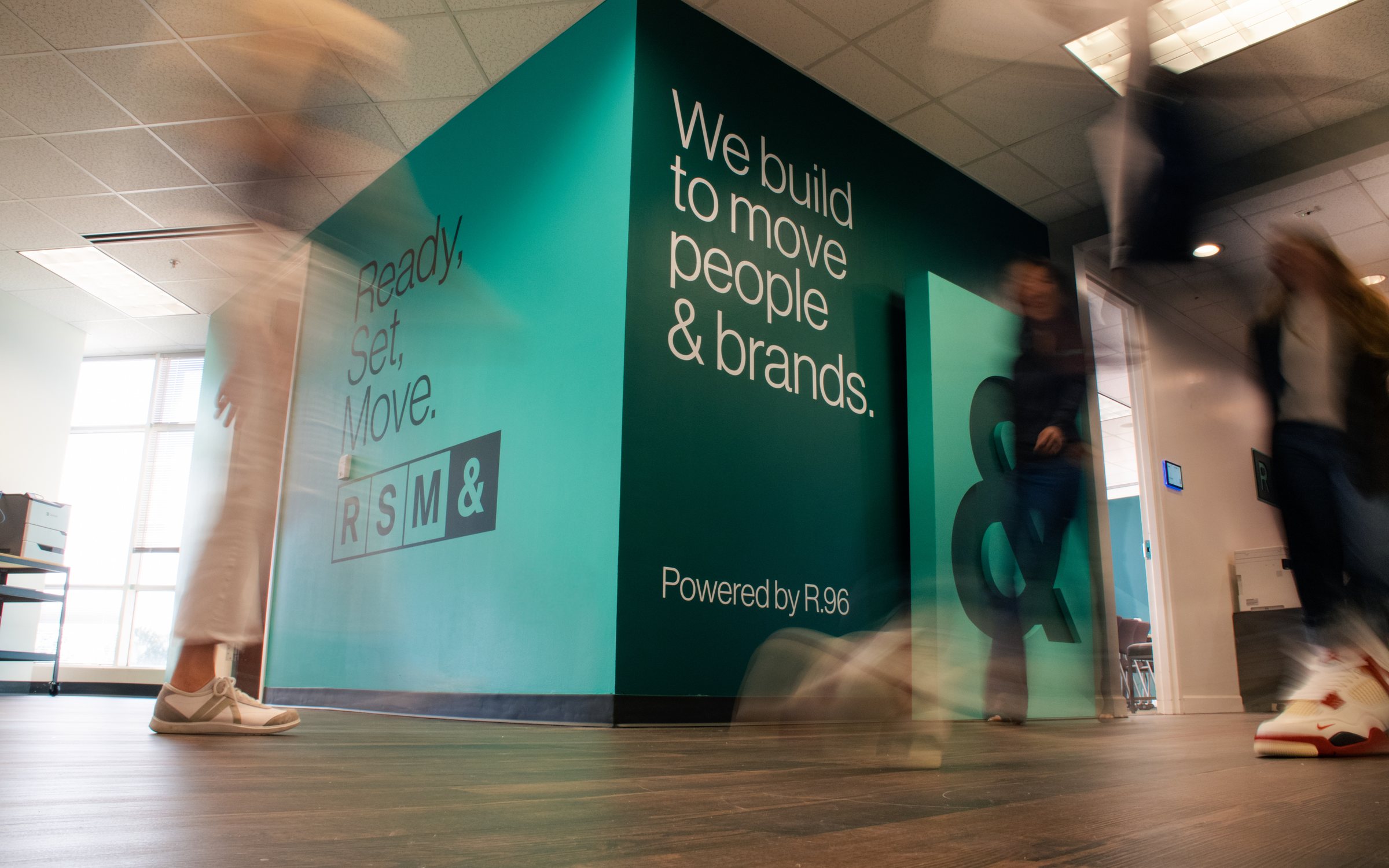 The RSM& office, with the "We build to move people & brands" wall