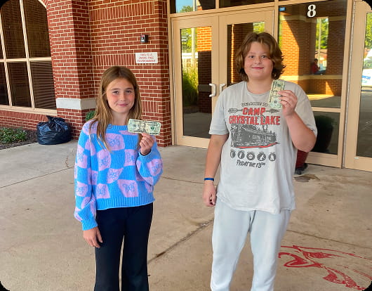 Fayette Central students hold dollar bills from their sales.